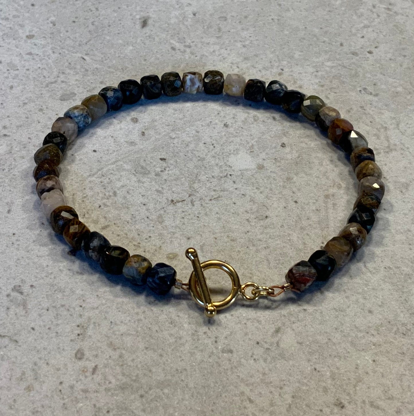 Armbånd i facetslebne pietersite sten
