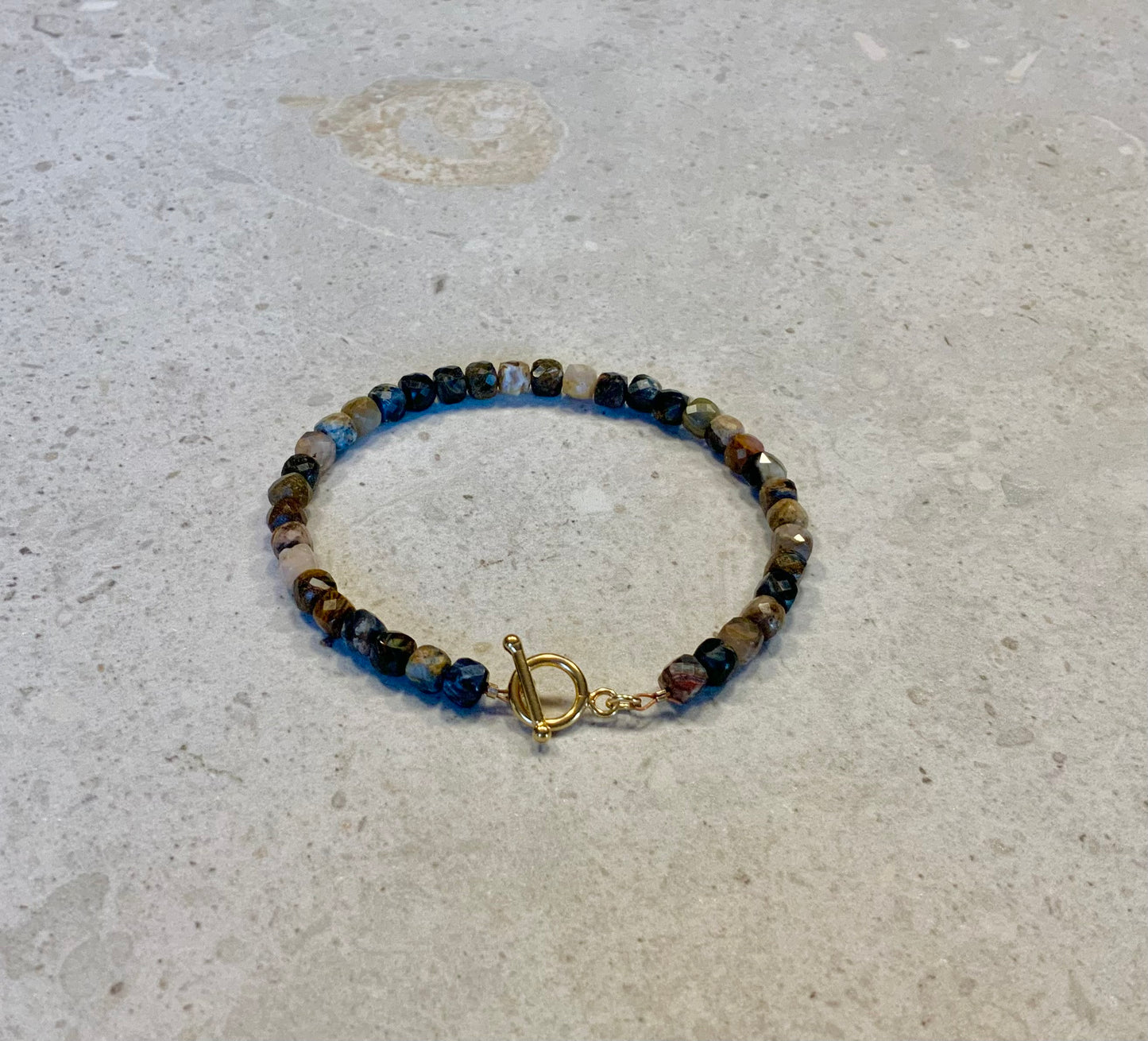 Armbånd i facetslebne pietersite sten