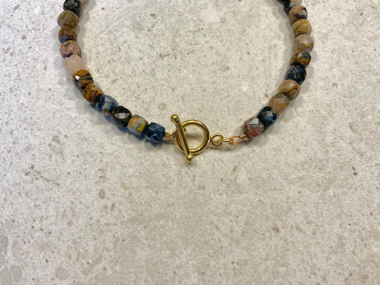 Armbånd i facetslebne pietersite sten