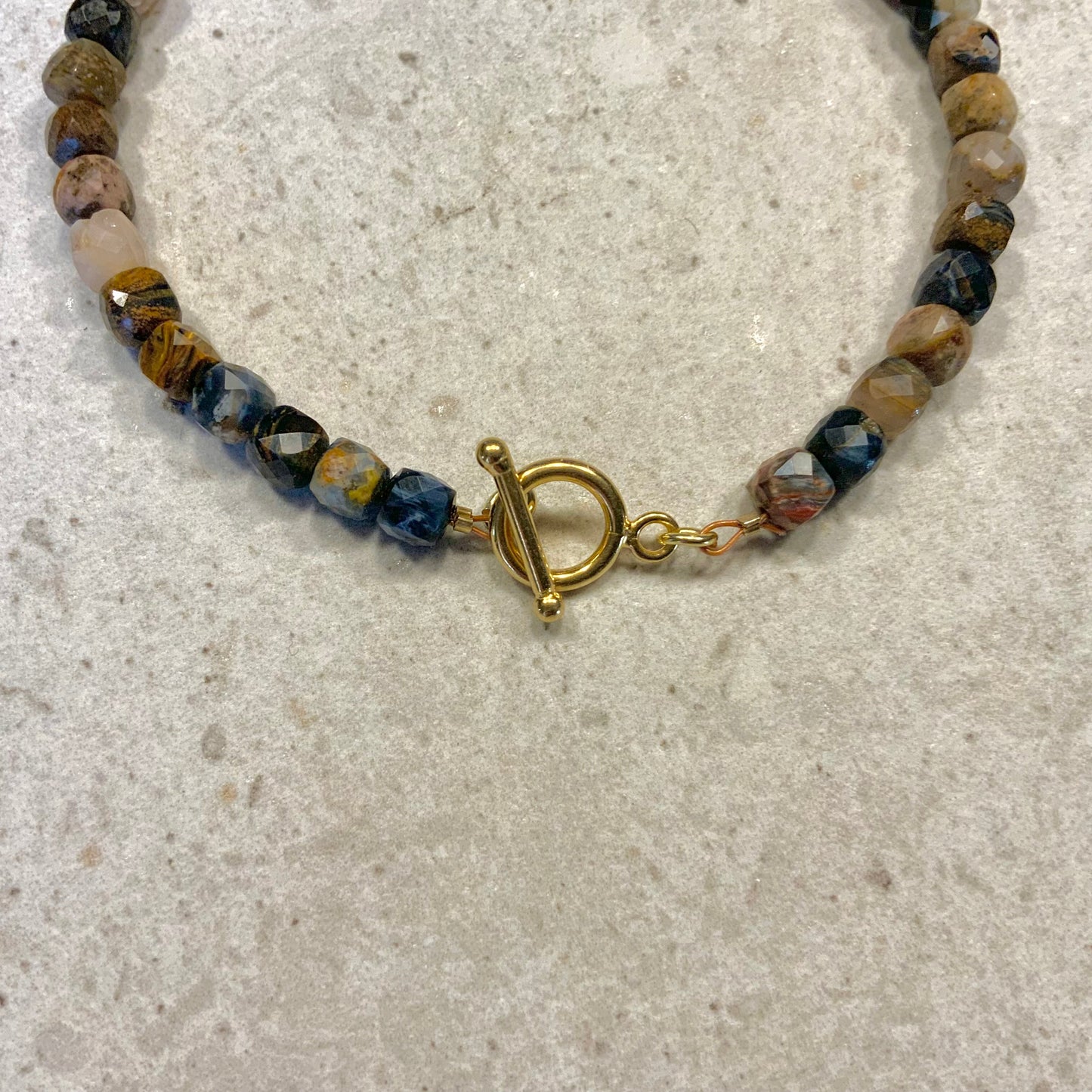 Armbånd i facetslebne pietersite sten