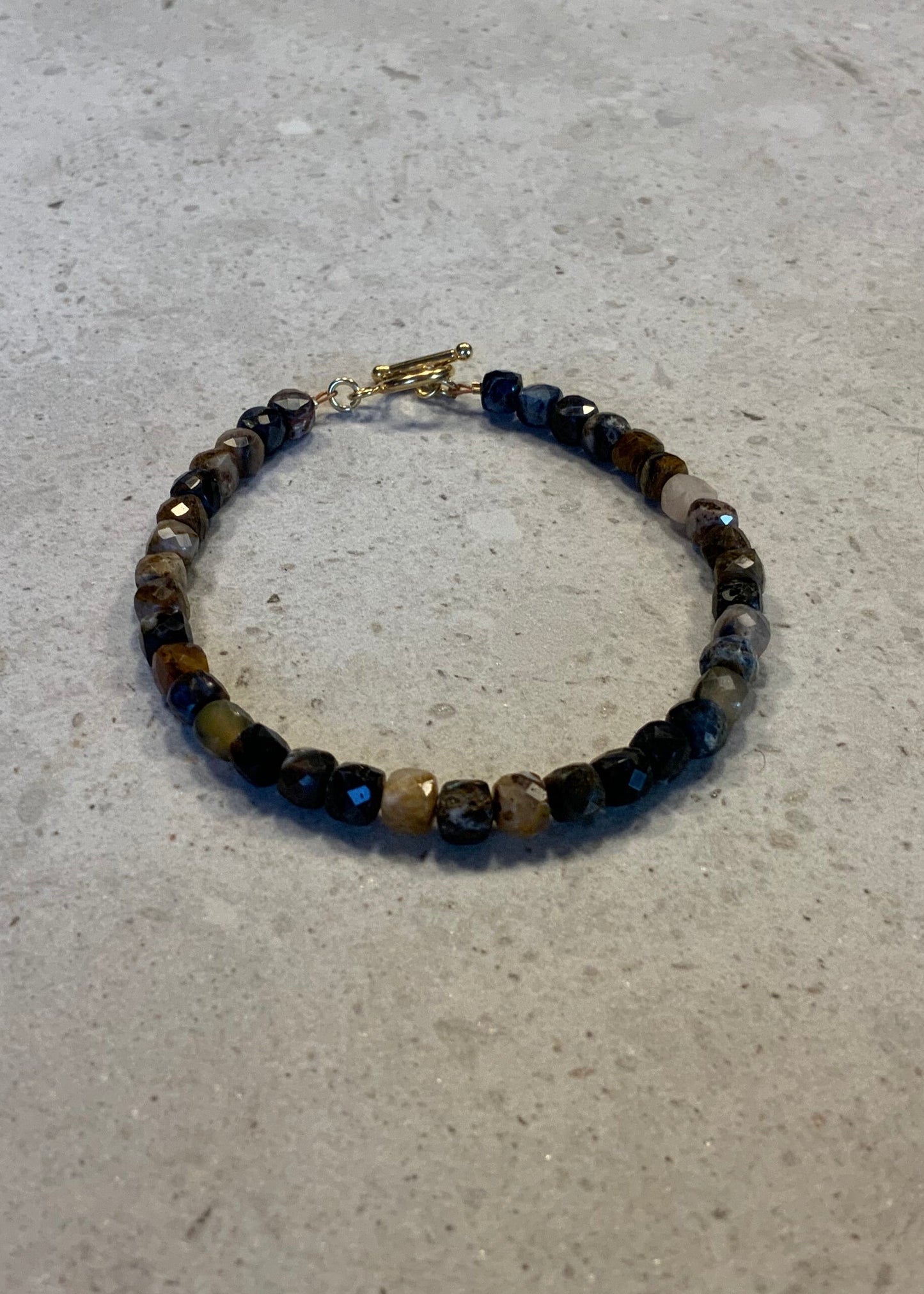 Armbånd i facetslebne pietersite sten